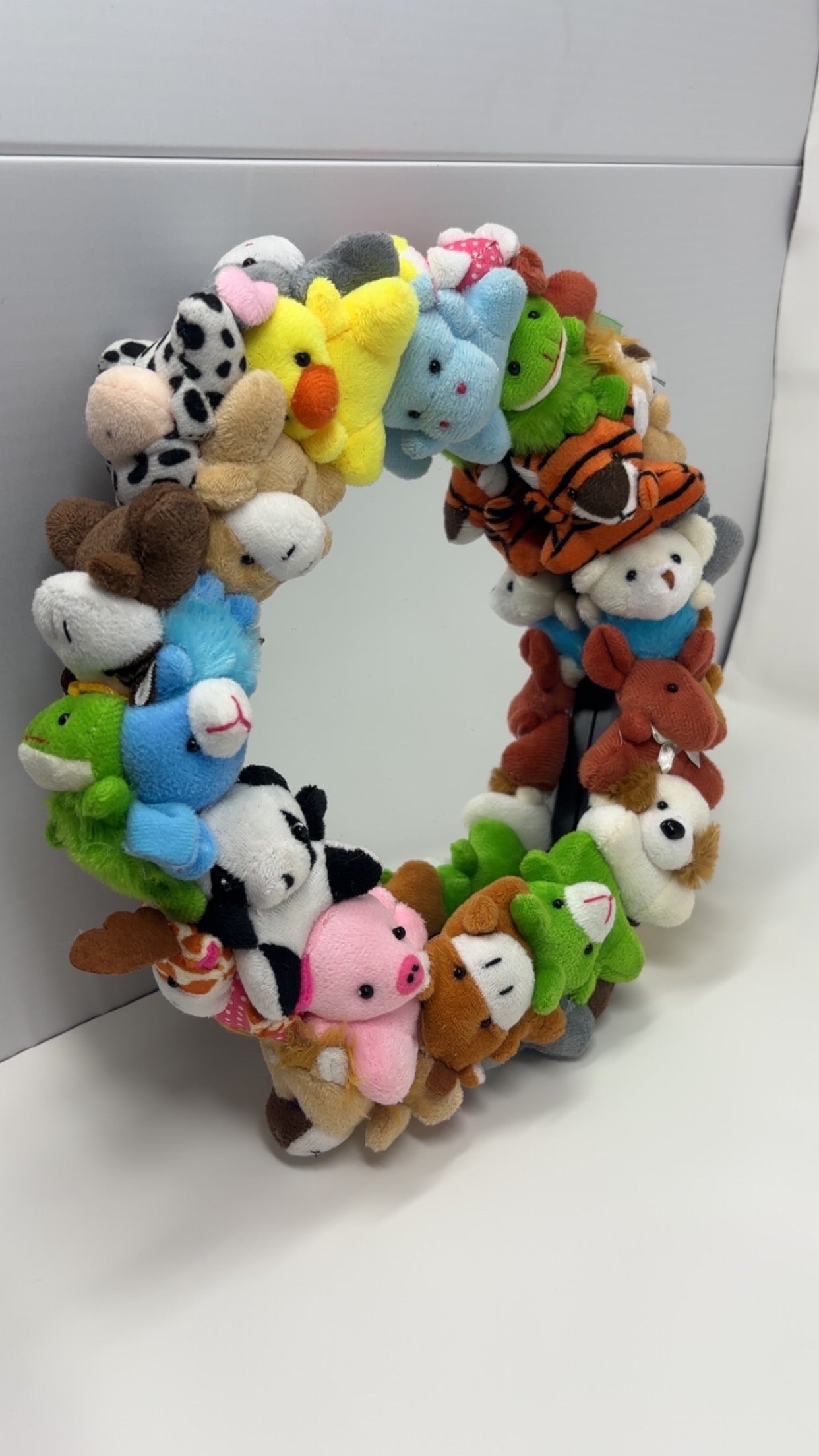 Wreath made of small plush animals on a white background
