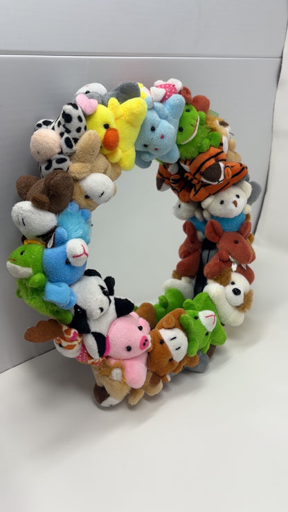 Wreath made of small plush animals on a white background